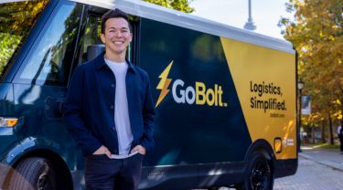 Mark Ang, cofondateur de GoBolt, souriant devant un camion qui arbore le logo et le slogan de GoBolt.